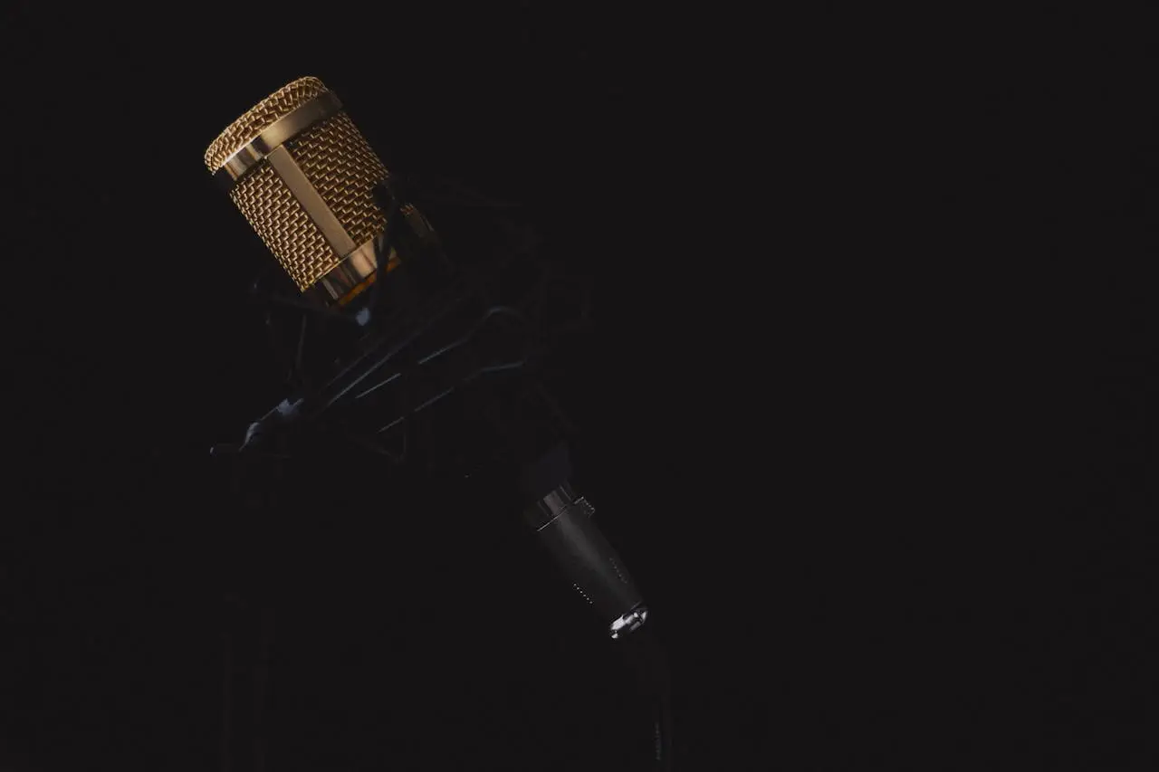Elegant golden microphone against a dark backdrop, perfect for recording studio illustrations.