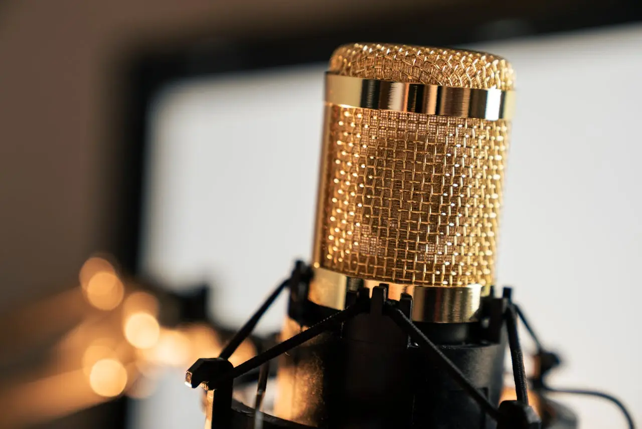A golden condenser microphone used for professional recording in a studio setting.